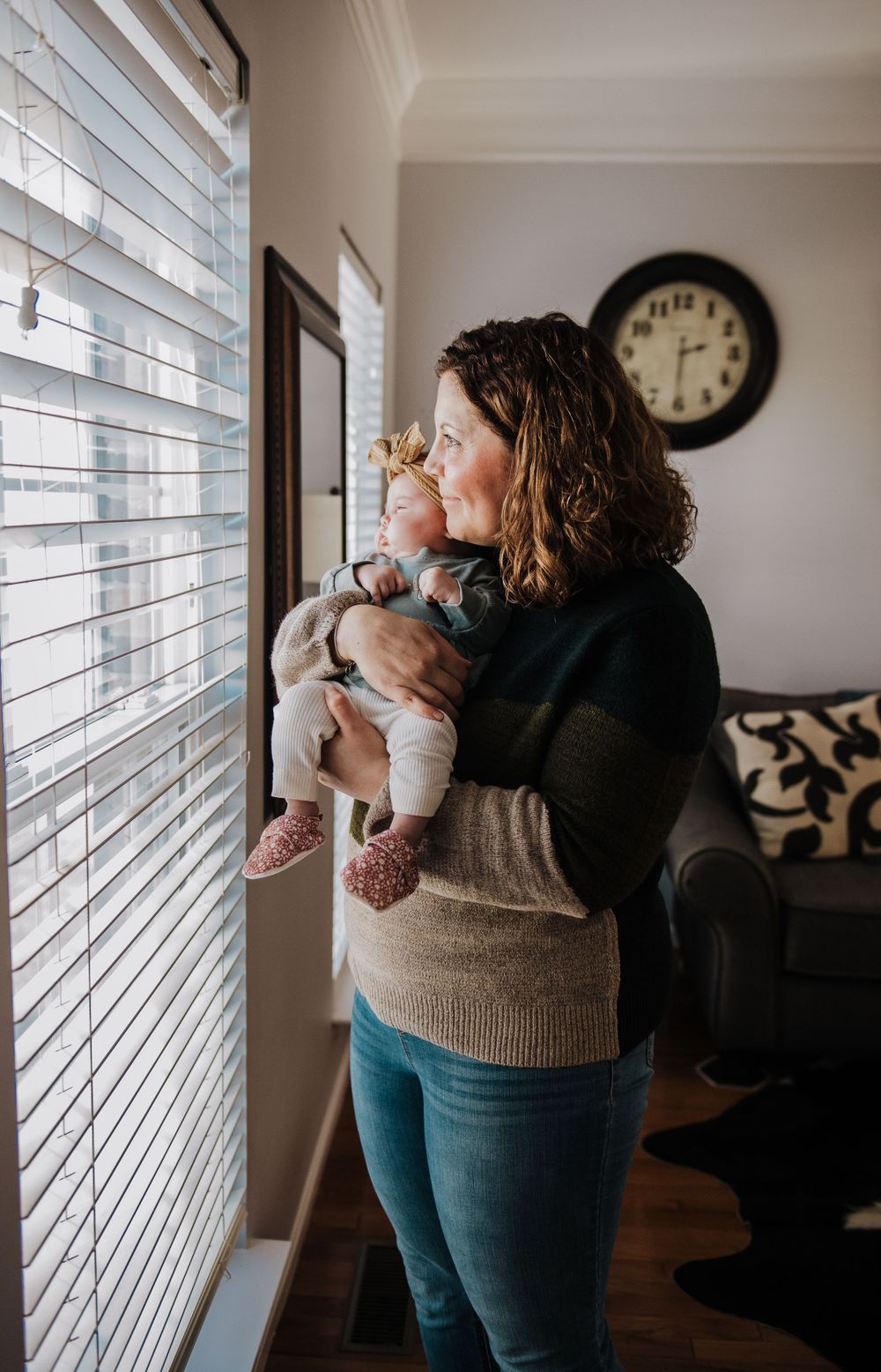 Candid moments by large windows showing gentle interaction with an infant.