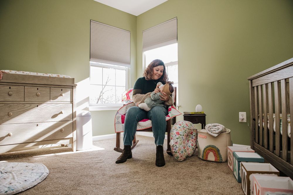 Lifestyle photoshoot showing playful moments in a bedroom with light green walls and natural lighting.