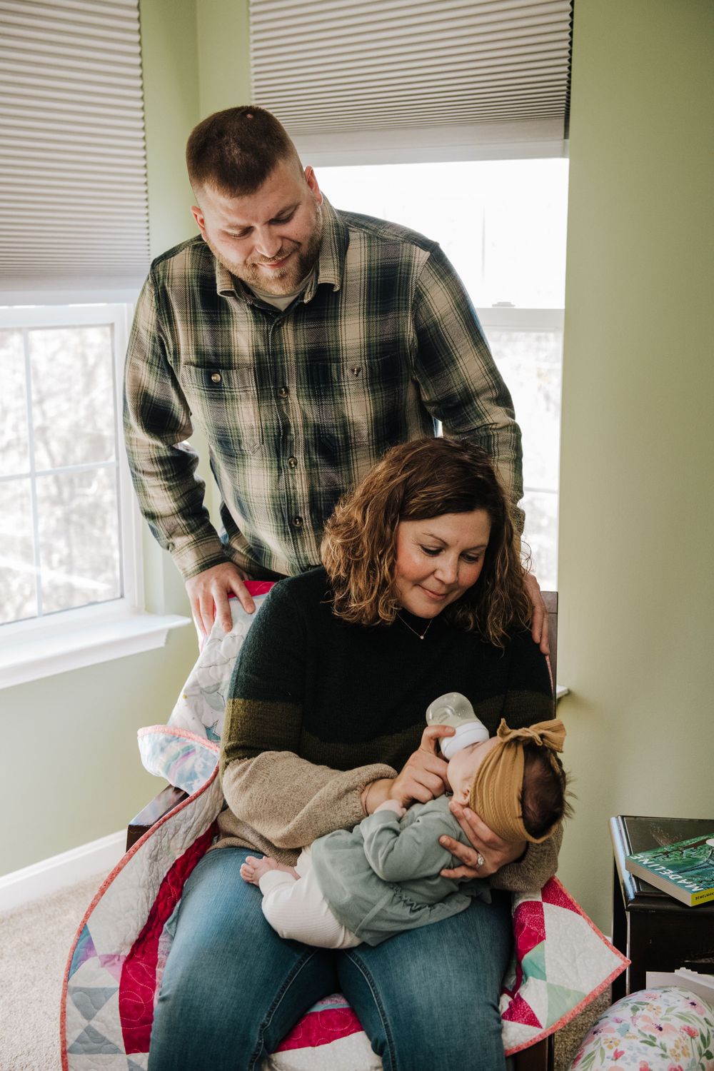Candid family photography by windows with mint green walls and natural lighting.