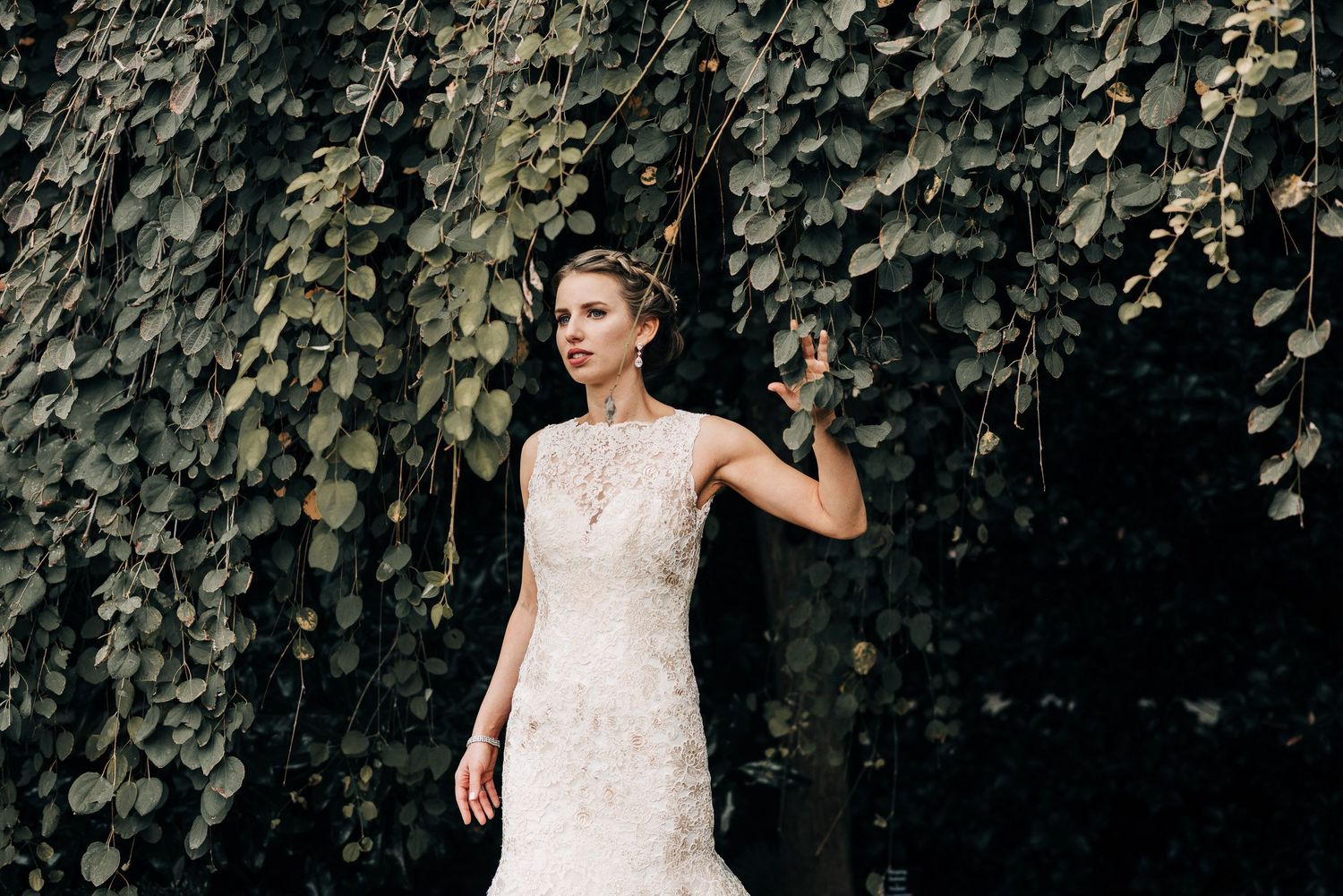 Elegant bridal portrait against a wall of lush green ivy.
