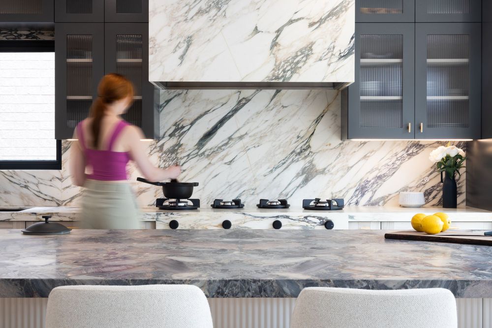 Luxurious kitchen with marble backsplash and dark stone countertops in motion blur effect.