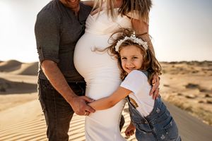 child hugging tummy maternity photos dubai desert