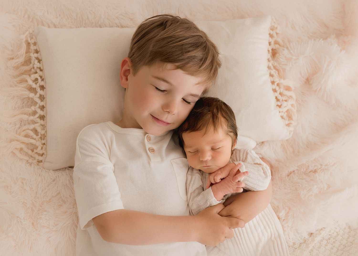 Tender family moment captured in soft beige tones on white bedding.