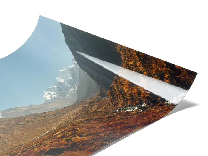 Curled edge photo print showing mountain landscape with autumn foliage.