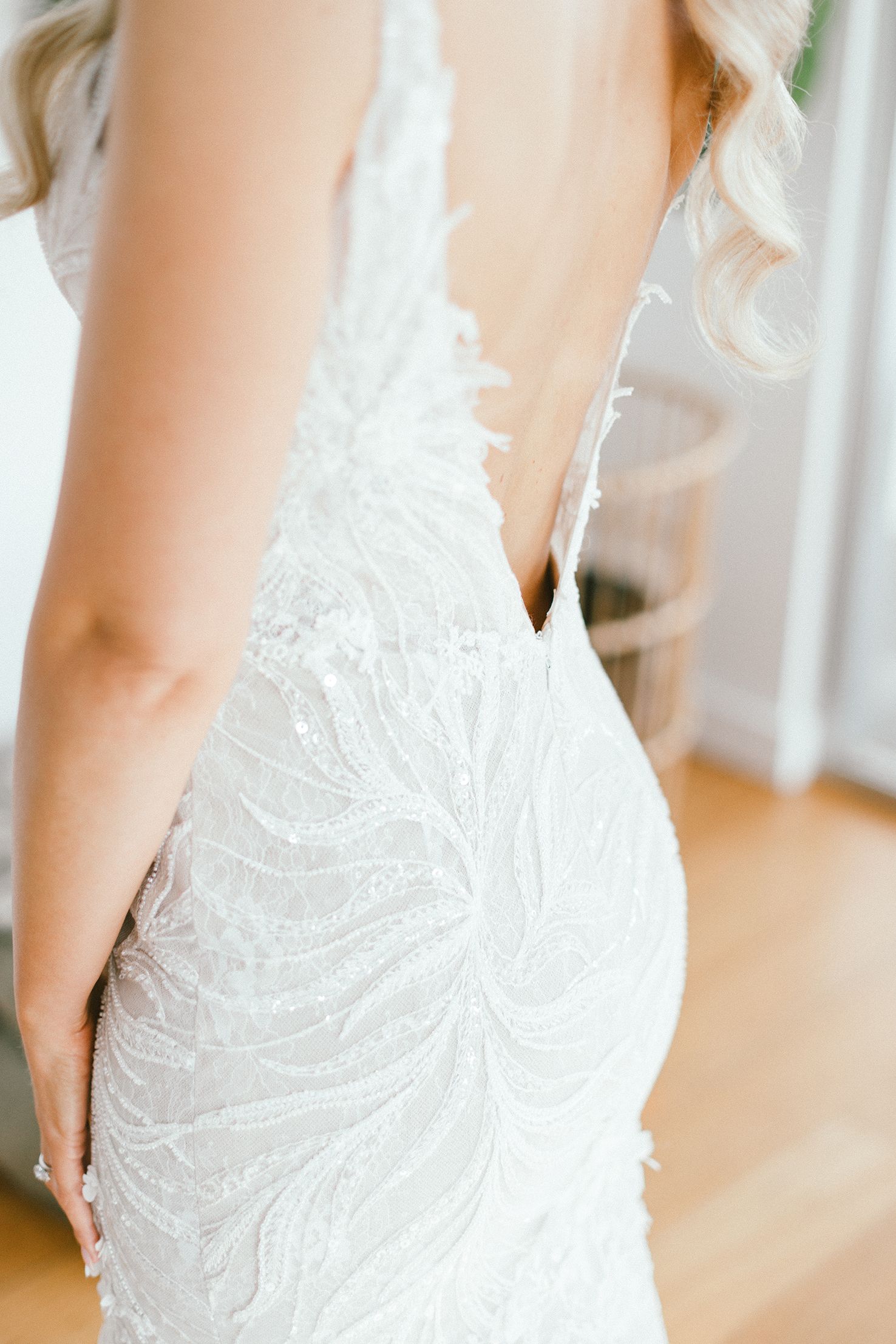 Close-up detail of an elegant white beaded wedding gown with intricate lace patterns.