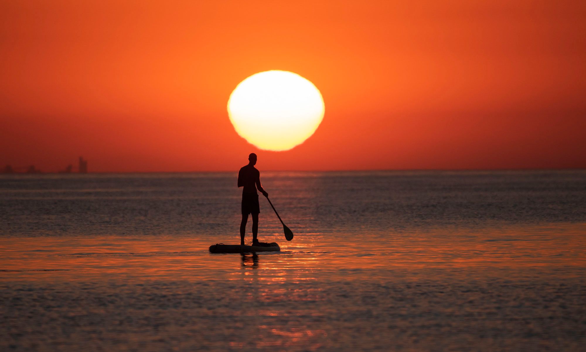 A lone paddleboarder in Cprus enjoys a morning Sunrise near Limassol.
