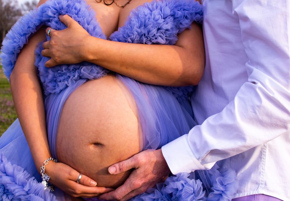 A series of maternity photos showing close-up details of a pregnant belly in a flowing purple dress.