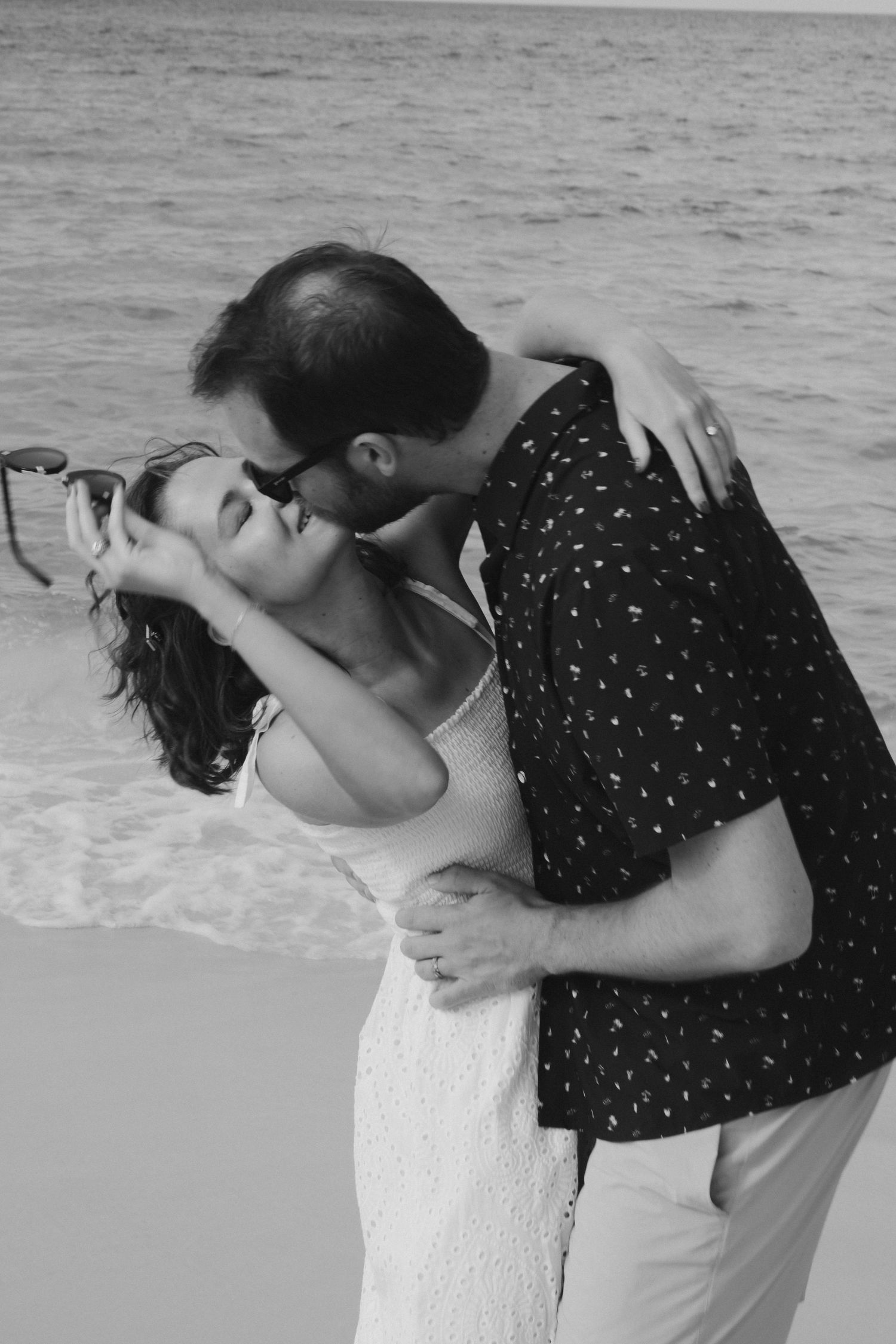 Romantic black and white series of an intimate moment on the beach.
