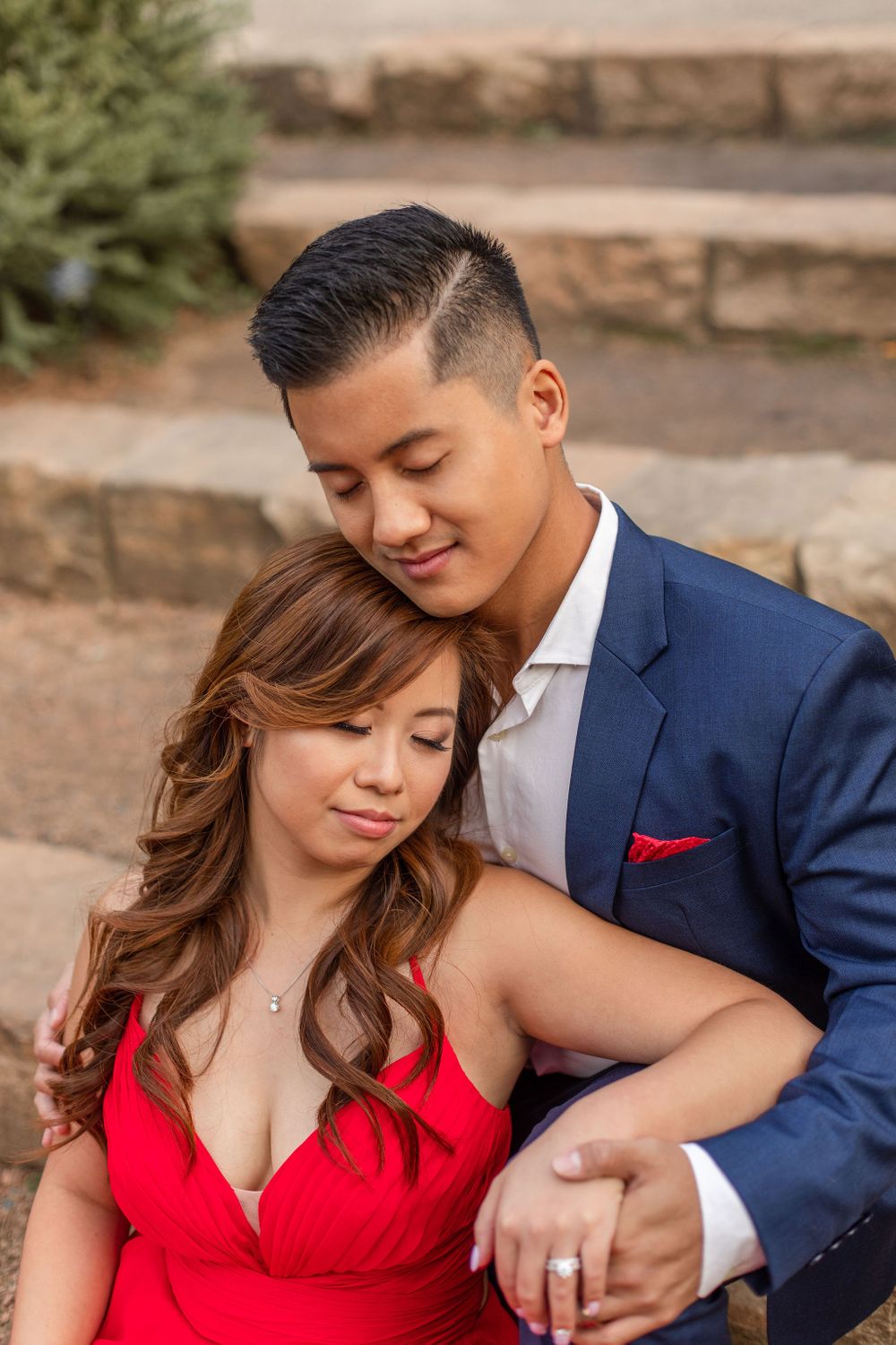 Intimate portrait of couple in formal wear against natural garden backdrop.