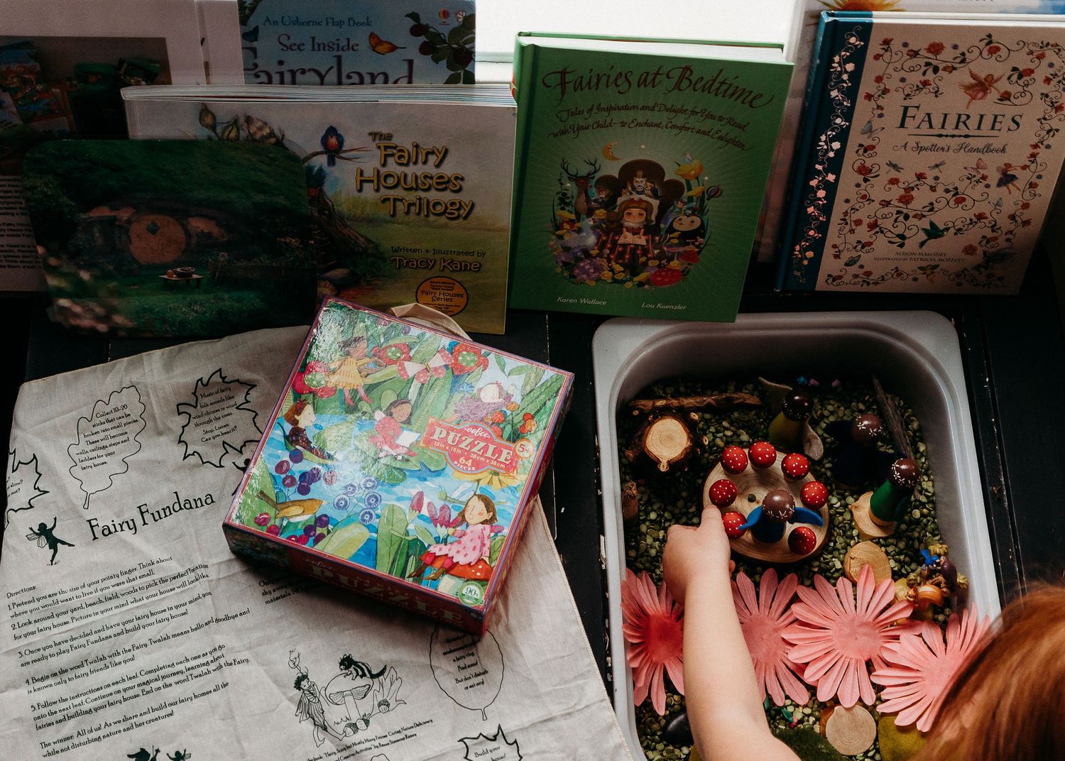 Collection of vintage fairy tale books and a box of seasonal decorations displayed on a dark surface.