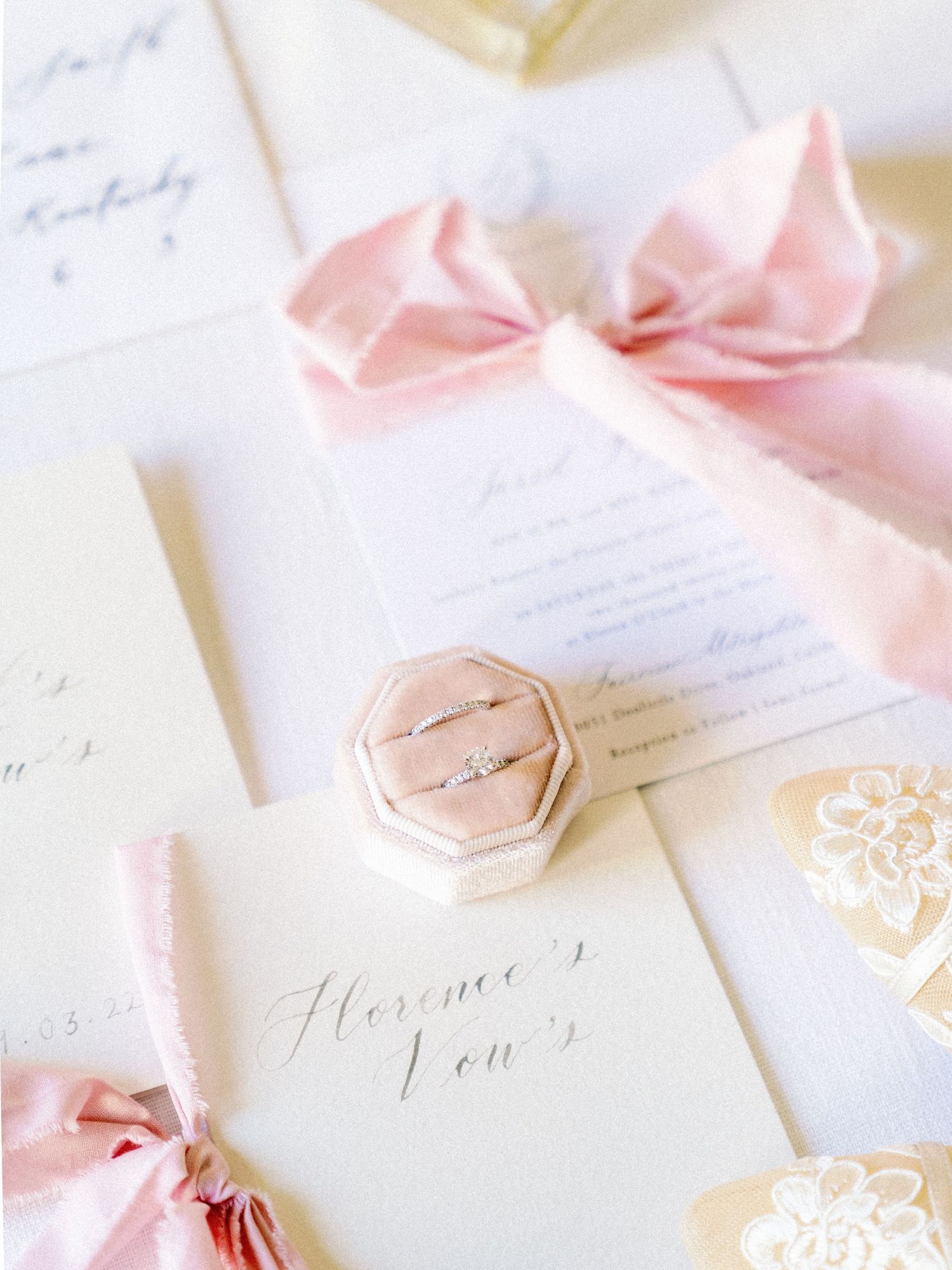Delicate wedding stationery with pink silk ribbons and a hexagonal ring box.