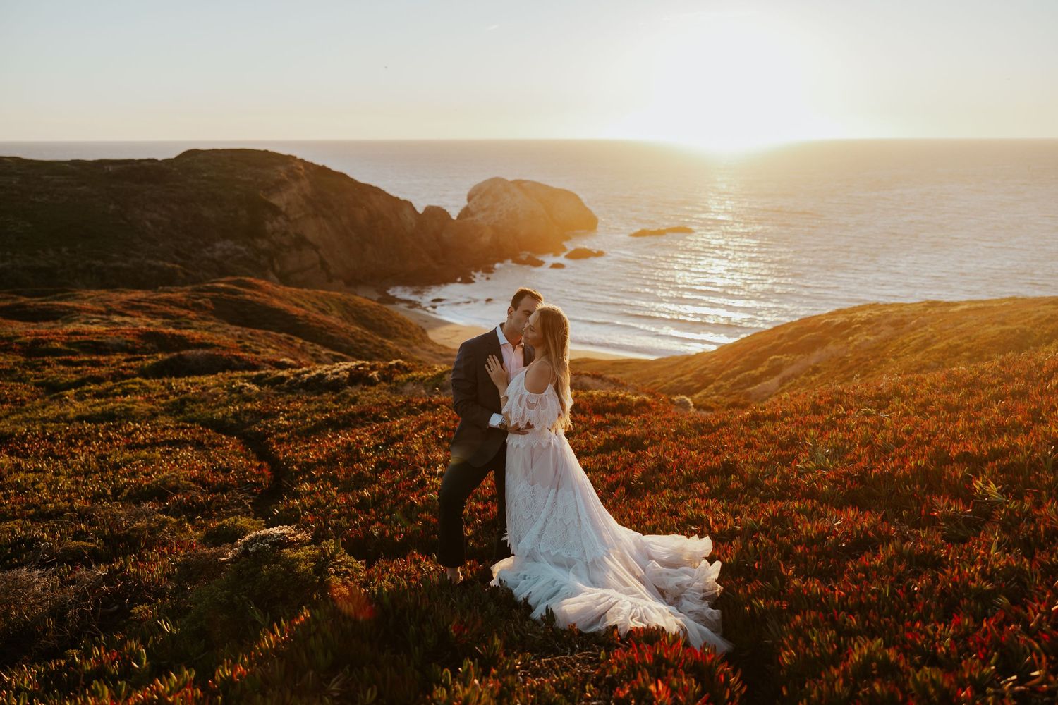 couple embracing on cliffside at sunset in marin headlands near san francisco for engagement photos
