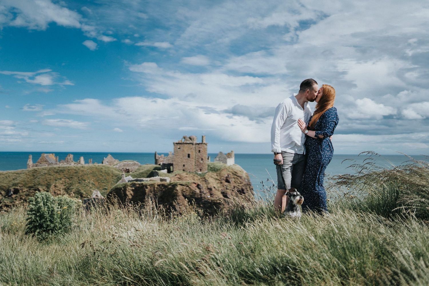 a couple kissing by an old castle