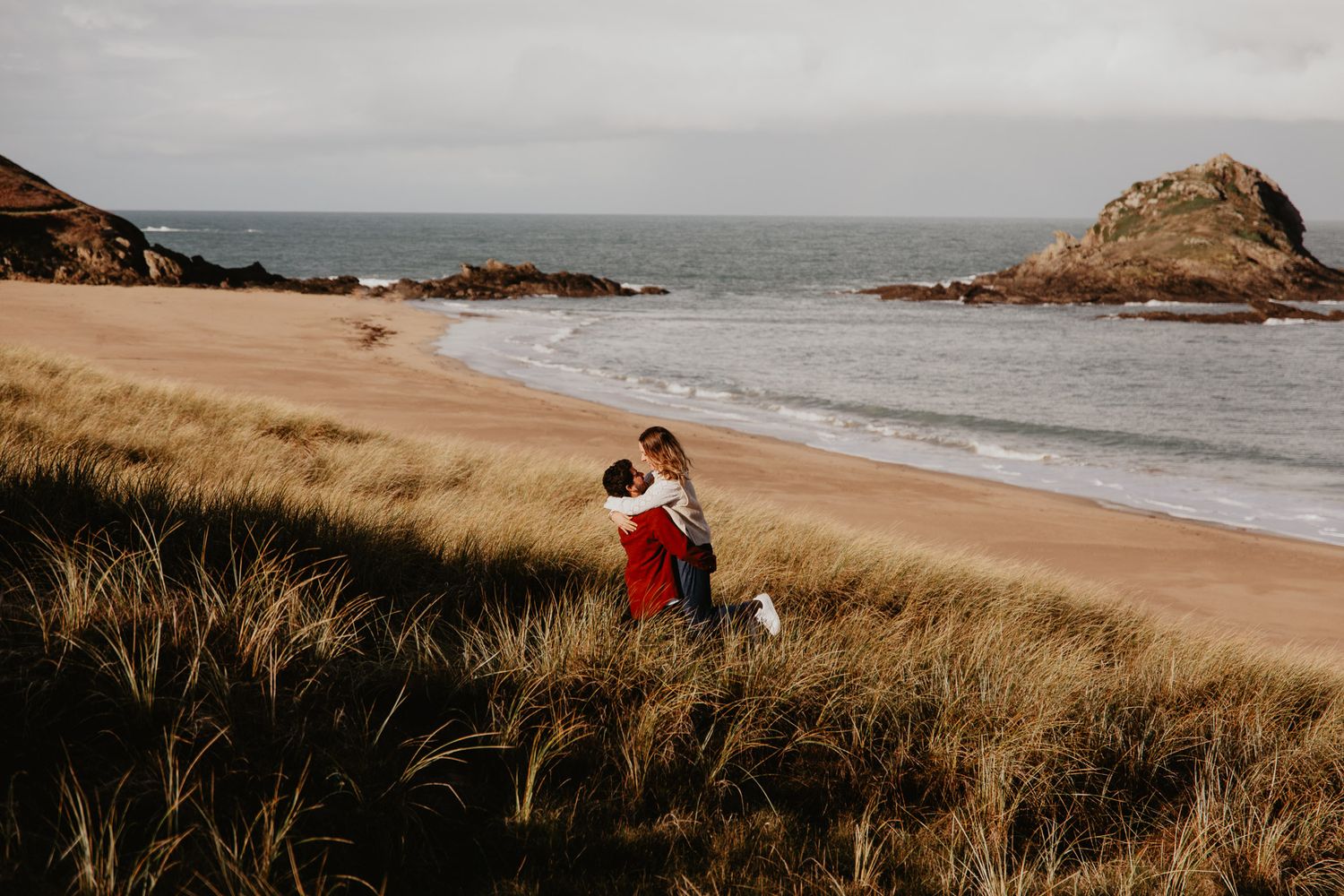 couple dans les hauts herbes devant la plage
