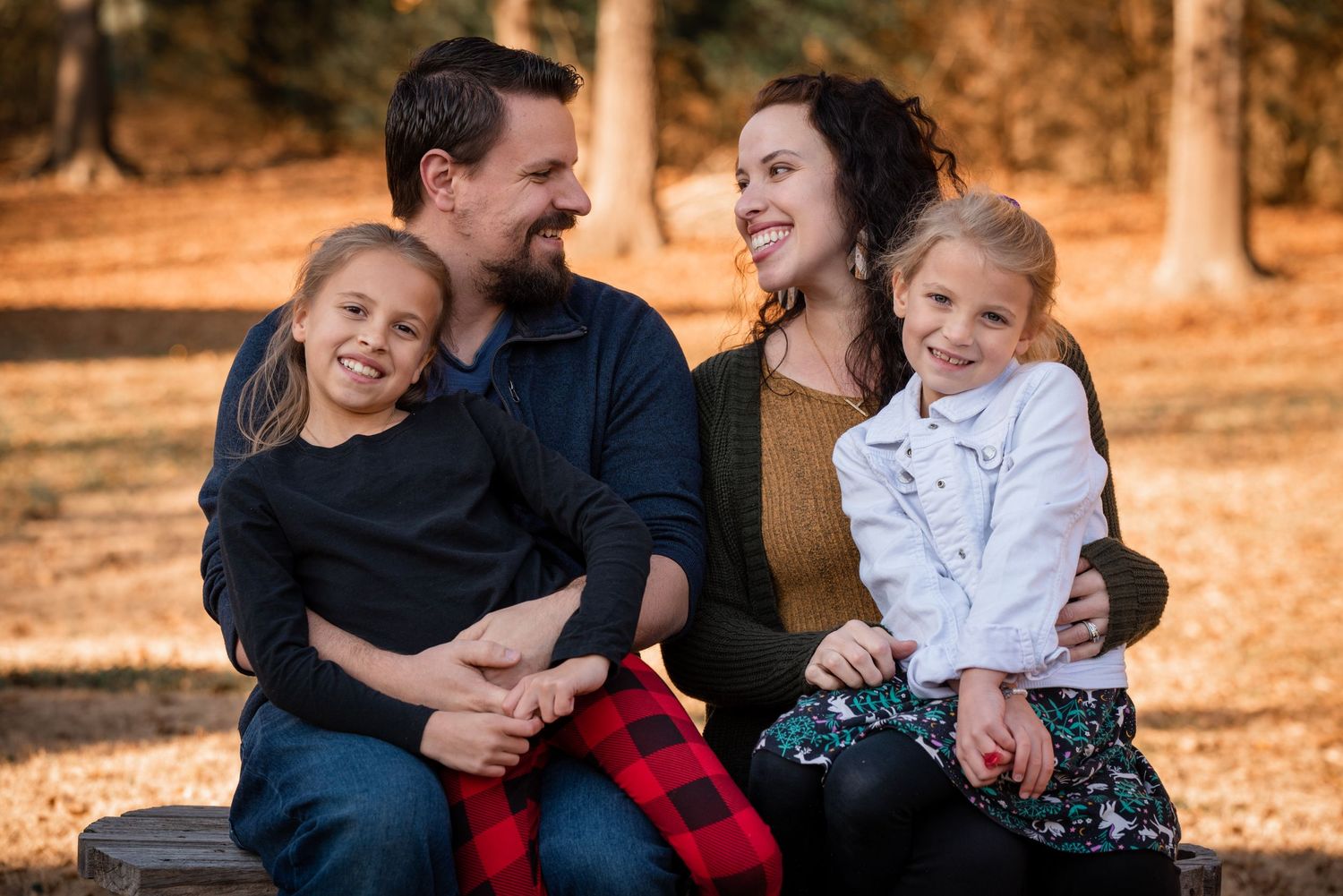 mother and father laughing with their daughters