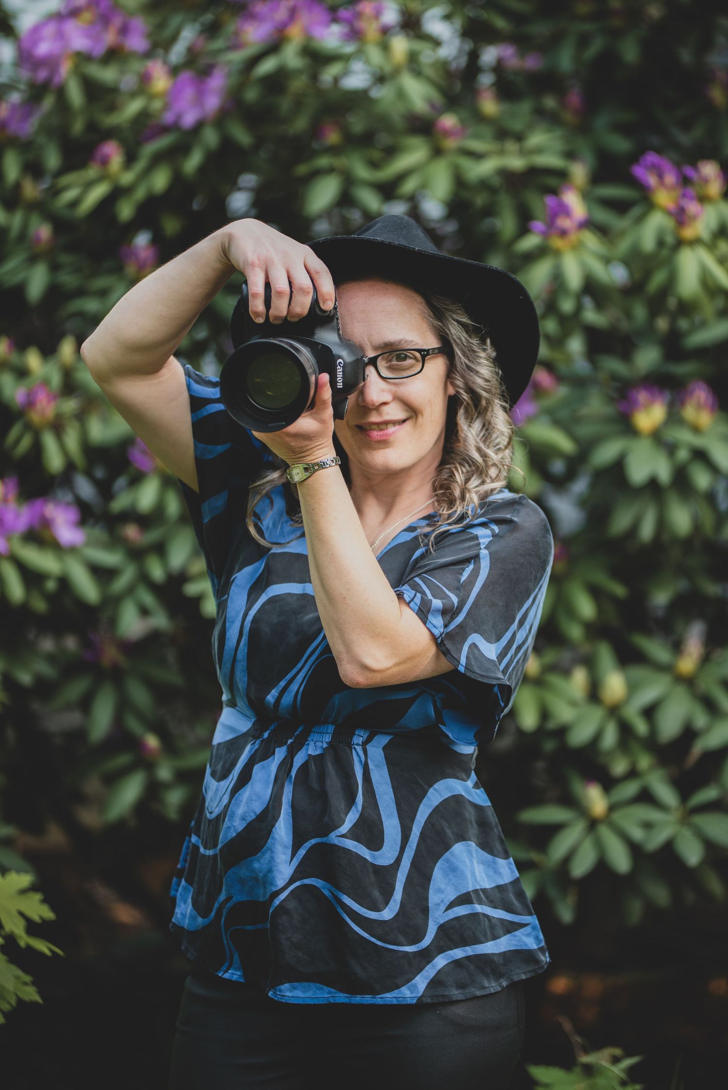 A photograph of Mary Frost the photographer with her camera up to her eye ready to take a photograph.