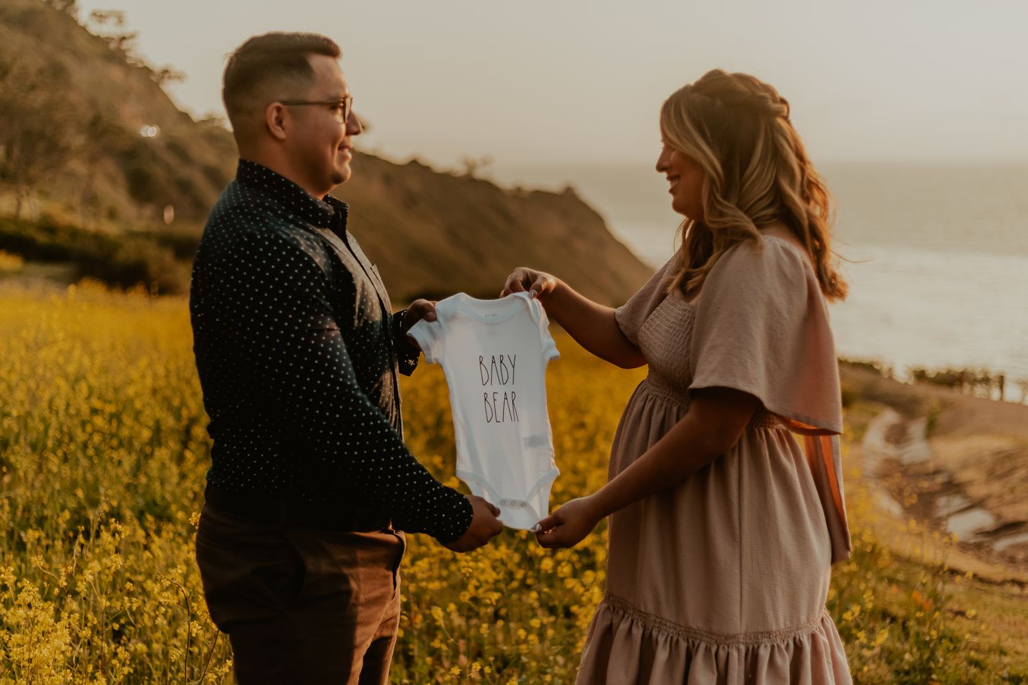 scenic couple pregnancy announcement photography in Palos Verdes, California in field of flowers and view of the ocean