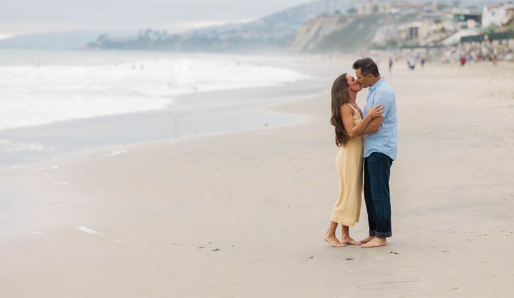 Engage couple kissing on the beach In Dana Point