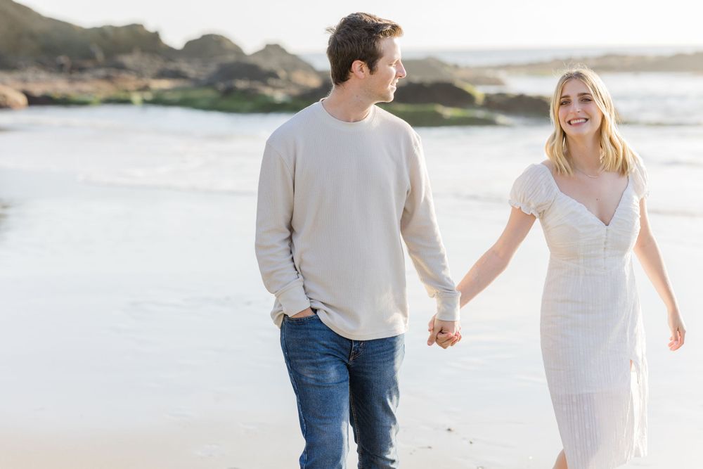 Engaged couple walking on the beach at Laguna Beach