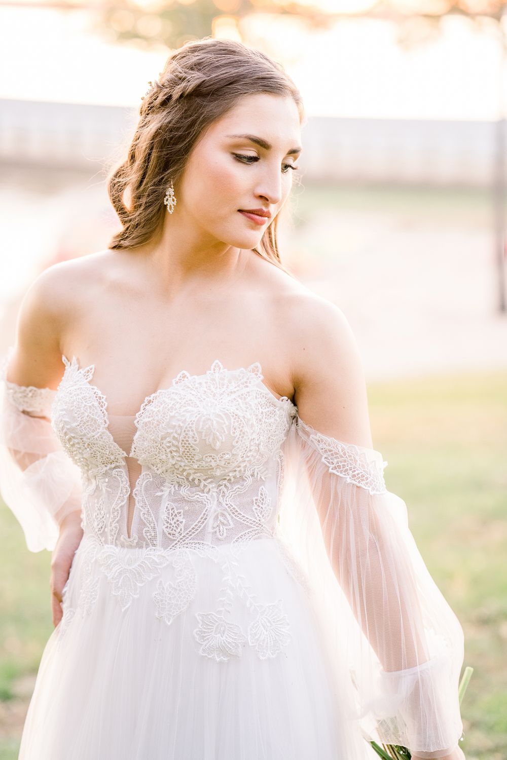 Off-shoulder lace wedding dress with delicate tulle sleeves and intricate bodice details.