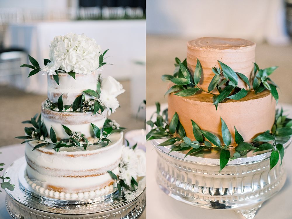 Two elegant wedding cakes decorated with white flowers and green foliage on crystal cake stands.