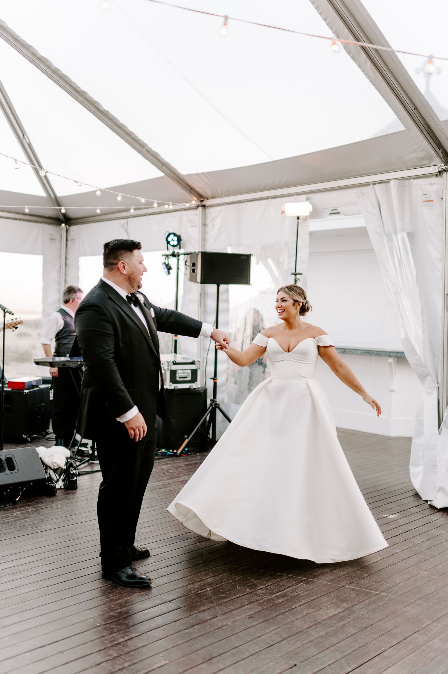 Playful wedding dance sequence under a white tent showing couple's joyful movements.
