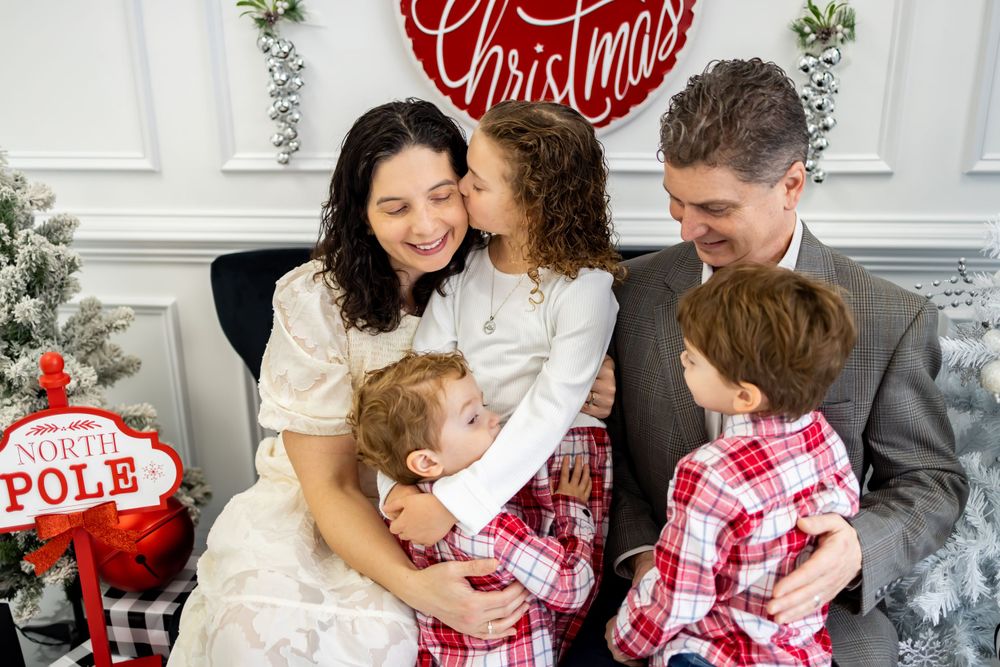 family of 5 kissing for their christmas photo