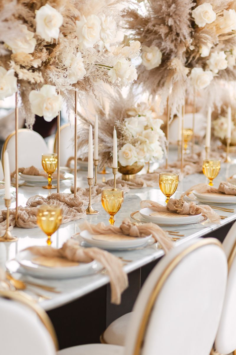 a detail view of a guest table decor with amber cups, brown napkins and white roses florals at Hudson Yards by Paula O