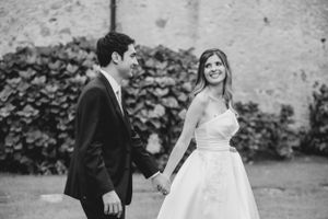 Black and white wedding portraits against textured stone wall backdrop.