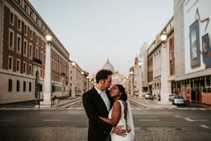 Wedding couple photographed along historic European city street.