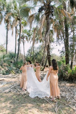 Johane's bridesmaids help her to attach her couture bridal cape designed by Casper Bosman.
