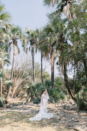 A bride's couture wedding dress is shown of in a editorial style pose in Letaba restcamp.
