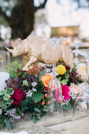 A rhino ornament and floral decorations on a wedding reception table.