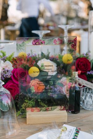 Wedding reception menu and flowers on a table.