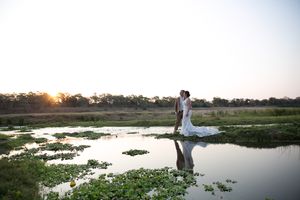 Dust and Dreams Photography captures this sunset portrait of a wedding couple standing in the Letaba river.