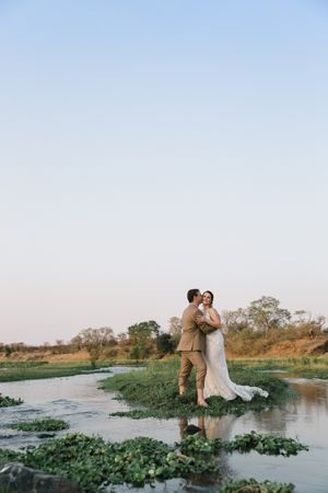 Wichert leans in for a kiss while he is standing on an island in the Letaba river with his new bride.