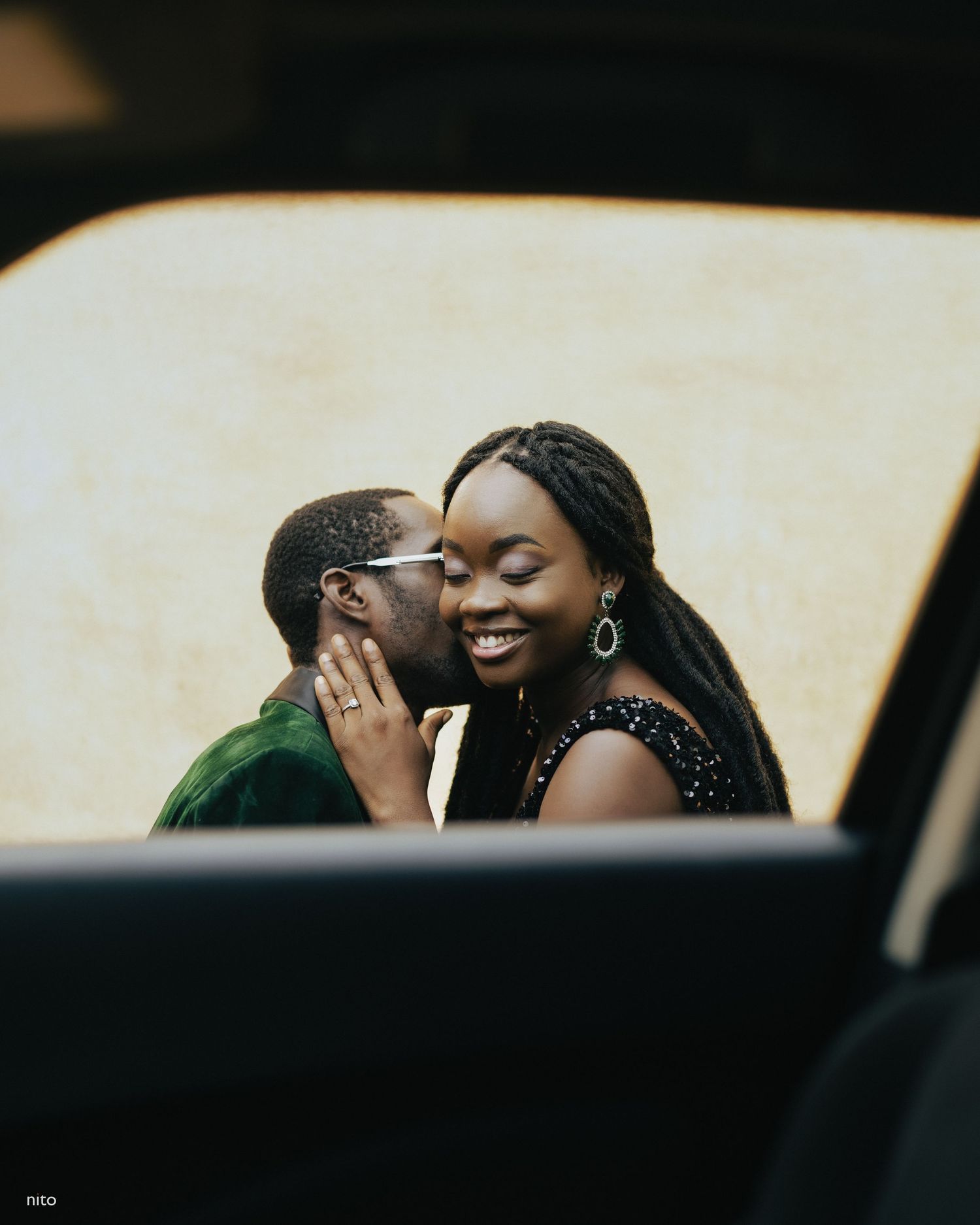 Intimate moment captured through car window with floral decorations in foreground.