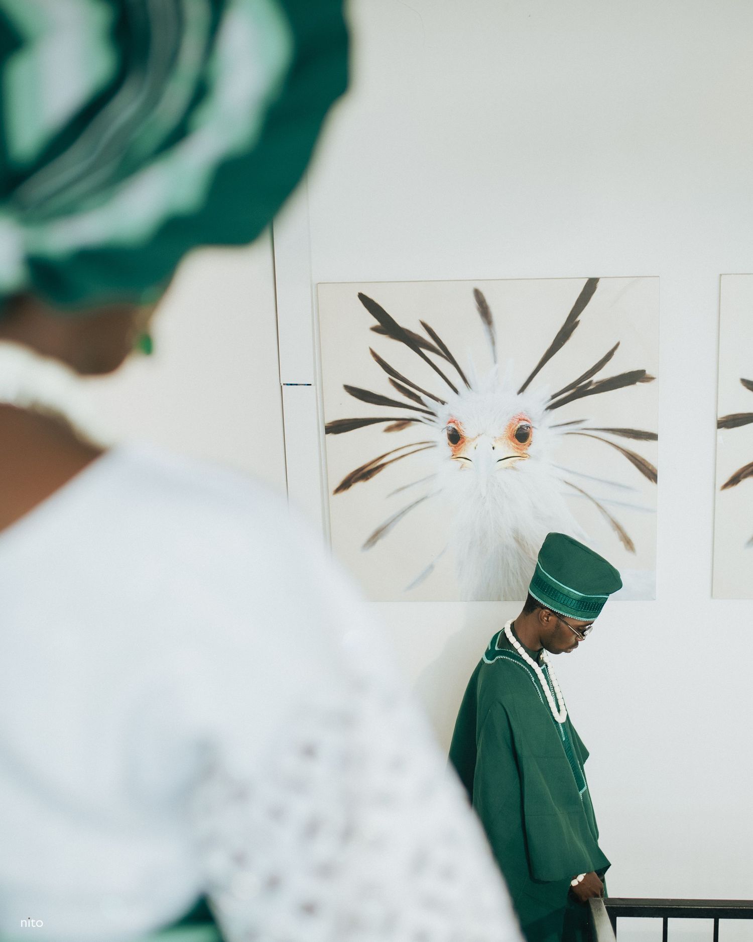 Artistic wedding photo showing emerald green traditional attire against abstract wall art.