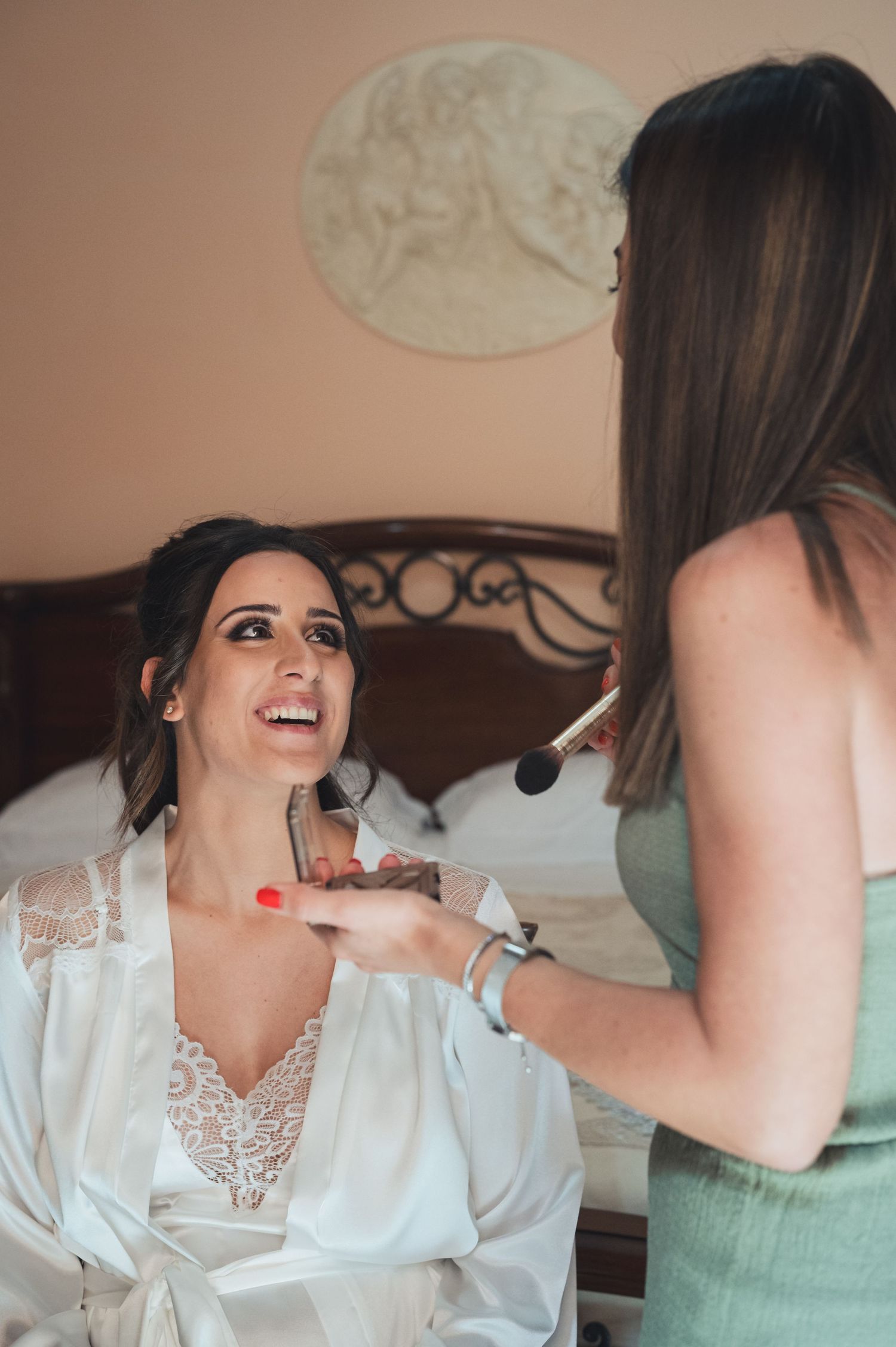 Professional makeup application in progress with brushes on a person wearing a silk robe.