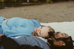 A couple rests on a beach blanket sharing a special moment during autumn.