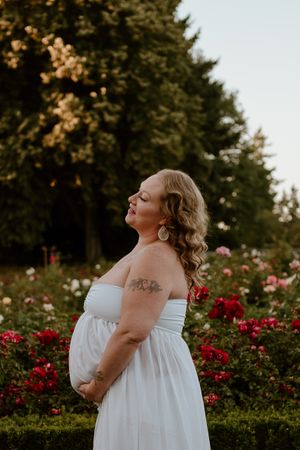 Peaceful garden portrait surrounded by red roses and white blooms at sunset.