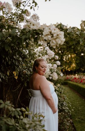 Dreamy portrait in a rose garden with white blooms and soft evening light.