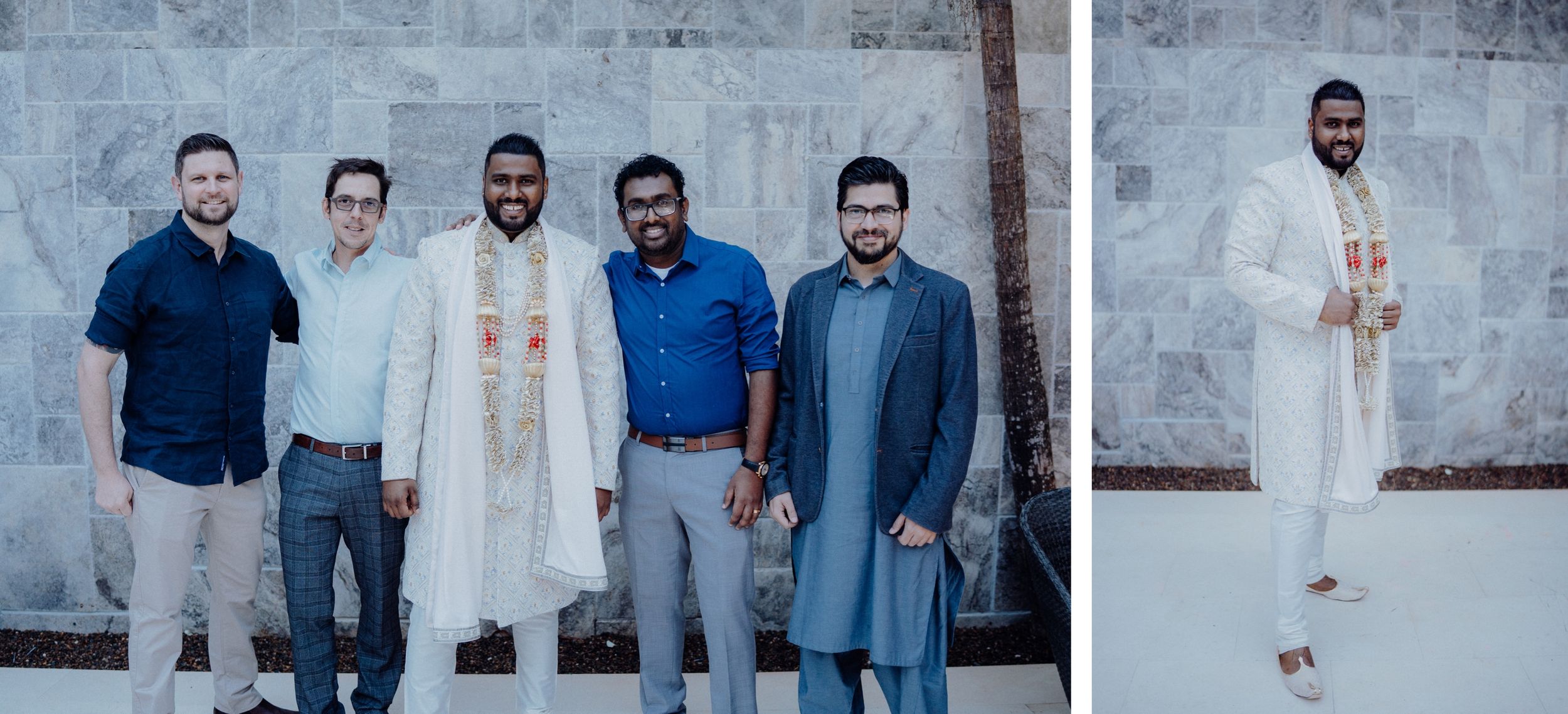 A group stands together against a concrete wall wearing traditional and modern attire at a cultural celebration.