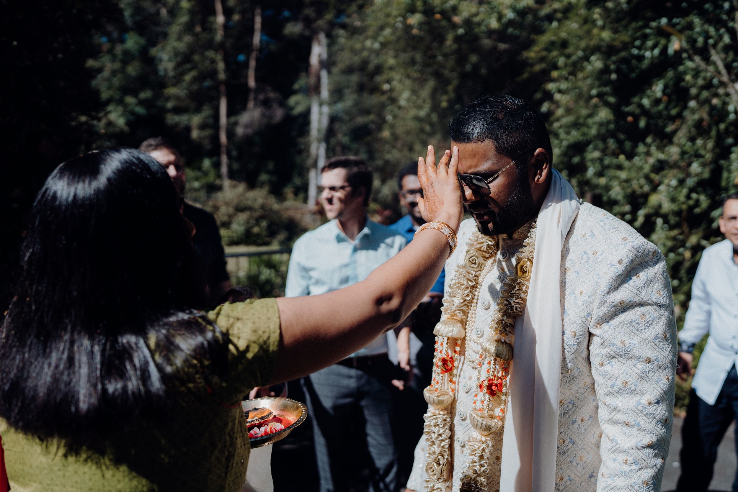 An outdoor ceremony moment showing traditional blessings being given during a celebration.