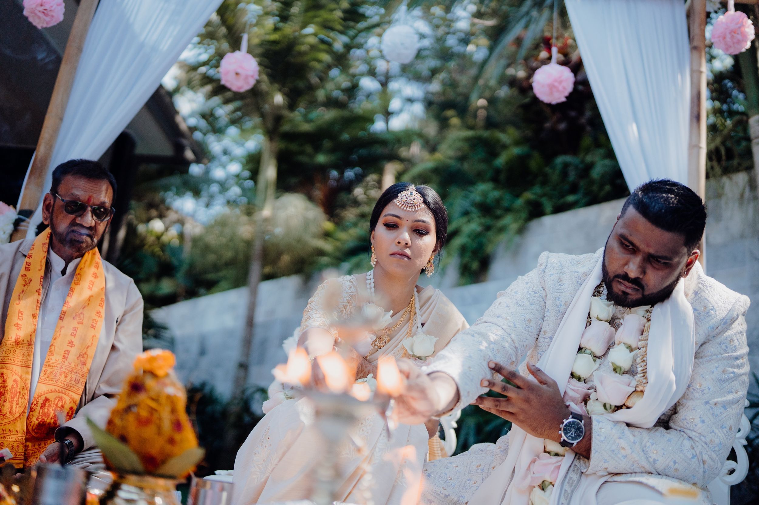 Traditional Indian wedding ceremony with candlelit decorations and white draping.