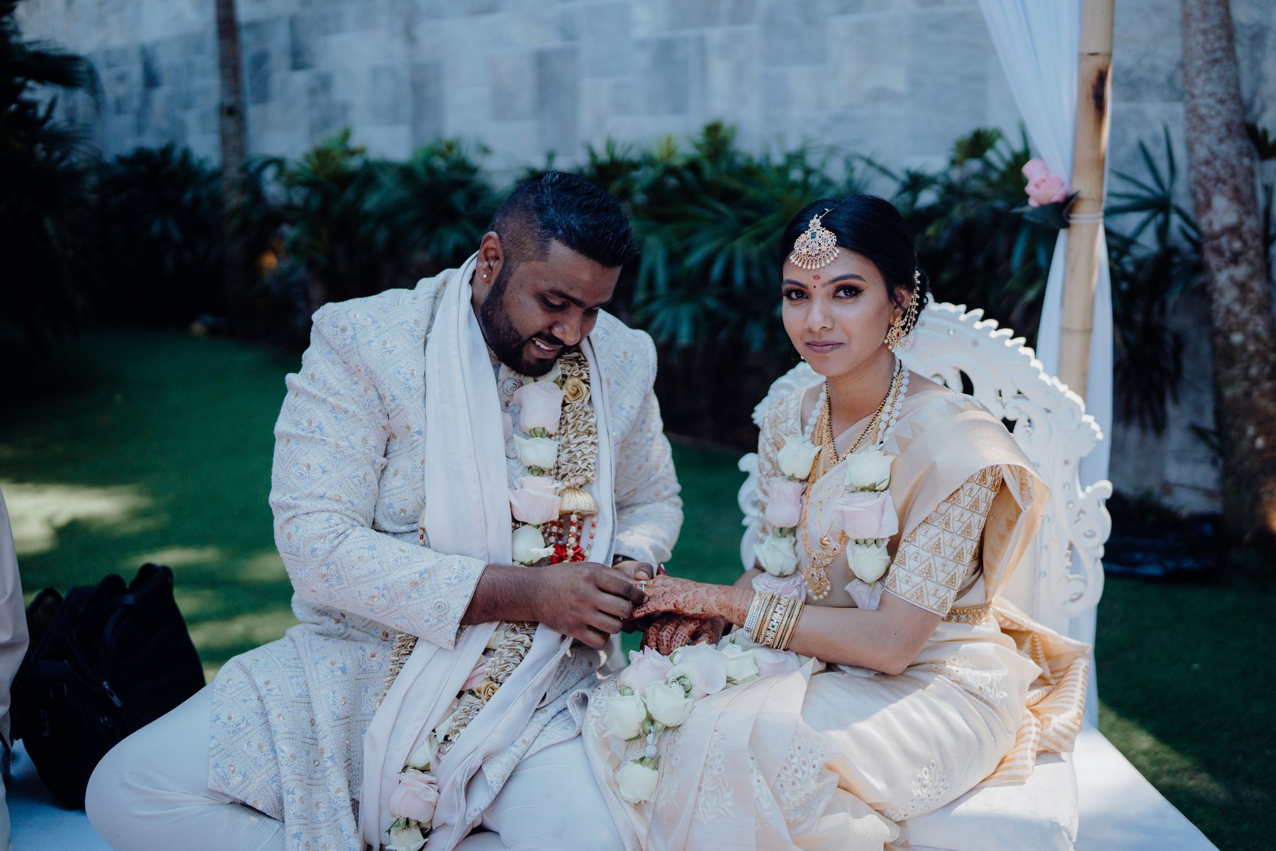 A couple in traditional white attire sharing an intimate moment during their wedding ceremony.