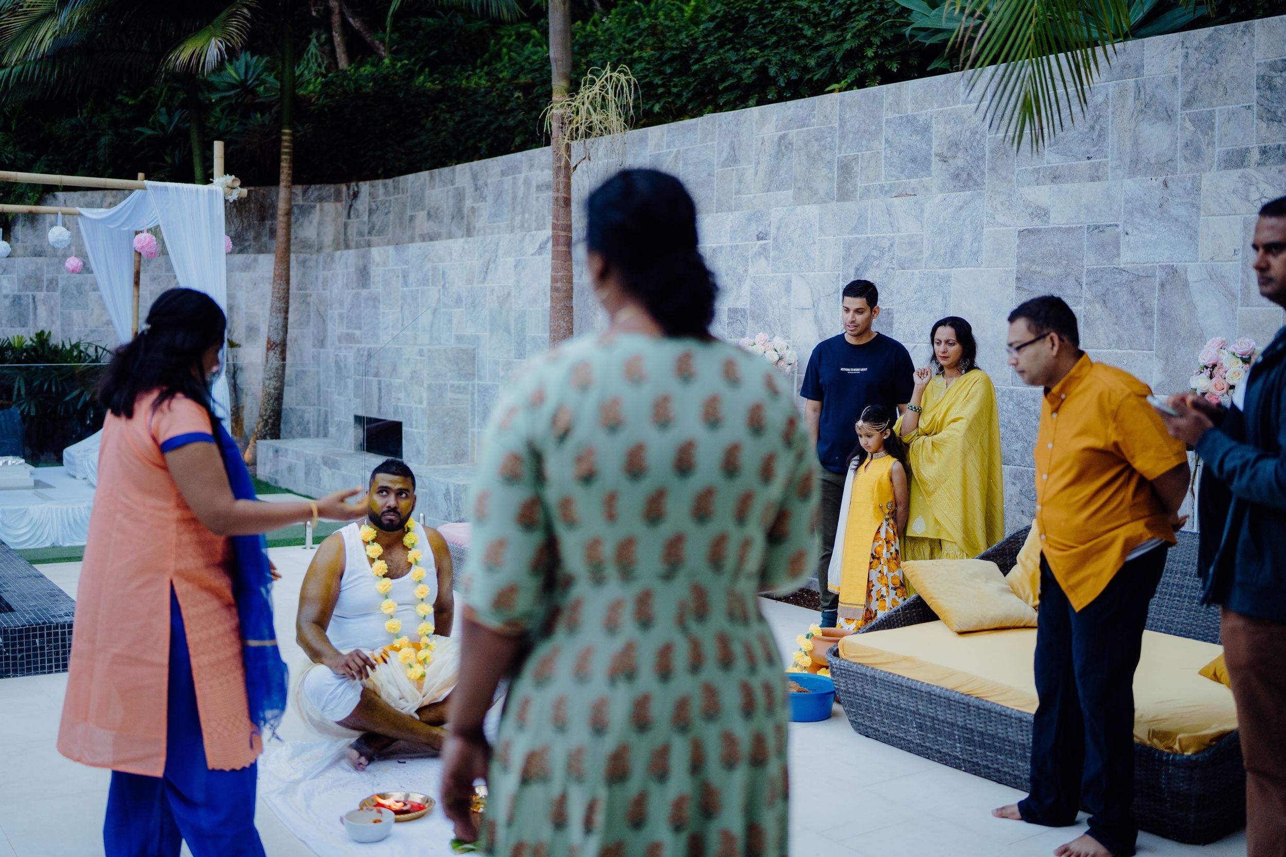 Guests participating in a traditional ceremony in an outdoor garden setting.