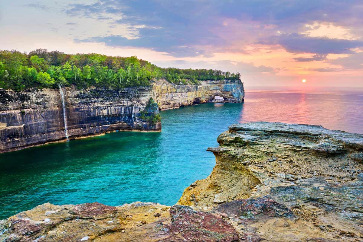 Dramatic cliffs and turquoise waters at sunset along the limestone shoreline of Michigan