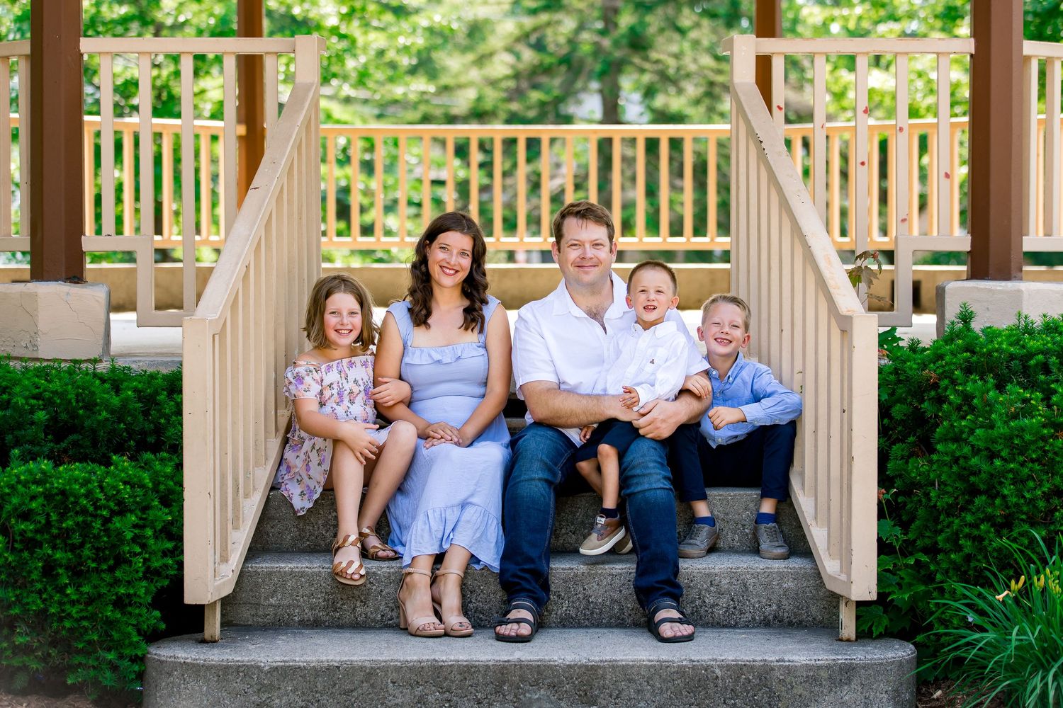 Family photo smiling together on the gazebo steps at beautiful park in Milton.