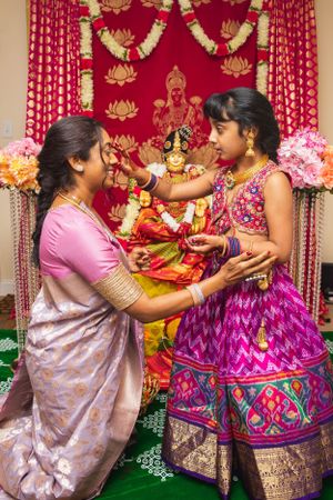 Traditional Indian cultural celebration with ornate decorations and red backdrop.